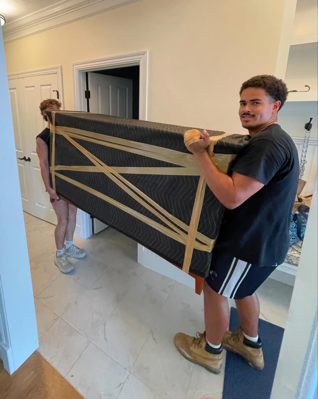 Cambridge moving services - Two professional movers carefully carrying furniture into home - Big Bear Movers Massachusetts